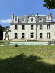 une grande maison avec une piscine en face de celle-ci dans l'établissement La Grande Carrée, à Saint-Cyr-sur-Loire