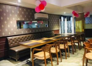 a dining room with a long table and chairs at Hotel Gwal Palace By WB Inn in Agra