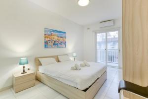 um quarto branco com uma cama e uma janela em Sant Antnin em Sliema