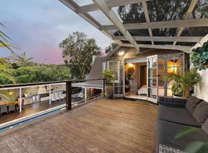 a house with a wooden deck with a view of the ocean at Sunset on Noosa Chalet in Noosa Heads