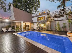 a house with a swimming pool in front of it at Sunset on Noosa Chalet in Noosa Heads