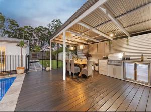 eine Küche und einen Essbereich eines Hauses mit einer Terrasse in der Unterkunft Sunset on Noosa Chalet in Noosa Heads