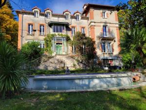 an old house in the middle of a yard at Le Temps des Cerises in Génolhac