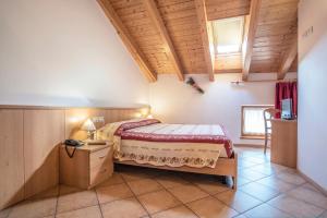 una camera con letto e soffitto in legno di Antica Residenza de Poda a Flavon