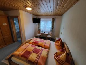 Un dormitorio con 2 camas y una mesa en una habitación en Hagauhof, en Kirchberg in Tirol