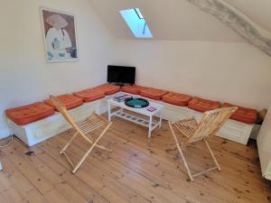 sala de estar con sofá, mesa y sillas en Le Temps des Cerises, en Génolhac