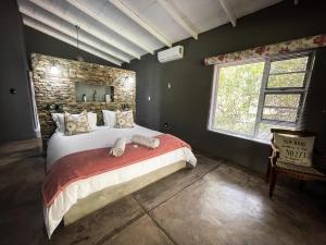 1 dormitorio con 1 cama grande y pared de ladrillo en Ukuthula @ the Kruger, en Marloth Park