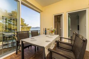 ein Esszimmer mit Tisch und Stühlen auf einem Balkon in der Unterkunft Guest House Malenica in Sukošan