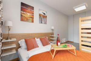 a bedroom with a white bed and a table at Apartamenty Porta Mare by Renters in Dziwnówek