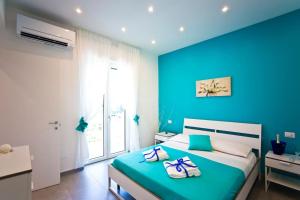 La Delizia - Sorrento في سورينتو: غرفة نوم زرقاء مع سرير عليه مناشف +19 صورة