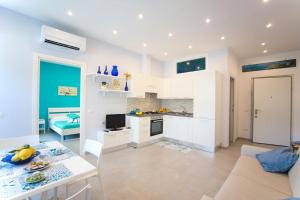 La Delizia - Sorrento في سورينتو: مطبخ وغرفة معيشة مع أريكة وطاولة