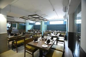 a dining room with wooden tables and chairs at Sunkissed Premium, Goa by WSI, Calangute Beach in Calangute
