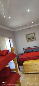 a bedroom with two bunk beds and red pillows at Immaculate 2-Bed Garden Cottage in Beaufort West in Beaufort West