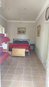 a bedroom with a red bed and a tiled floor at Immaculate 2-Bed Garden Cottage in Beaufort West in Beaufort West