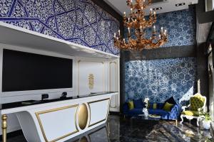 a living room with a tv and a chandelier at HMZ LUXURY HOTEL in Çekme