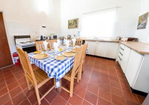una cocina con una mesa con un mantel azul y blanco a cuadros en Woodcliffe Country House, en Woodcliffs
