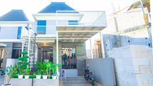 ein Haus mit einem Motorrad, das davor geparkt ist in der Unterkunft Villa Cendana Syariah Private Pool by Masterpiecevilla in Batu