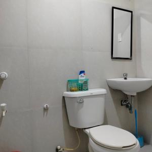 a bathroom with a white toilet and a sink at Guest Homey in Iloilo City