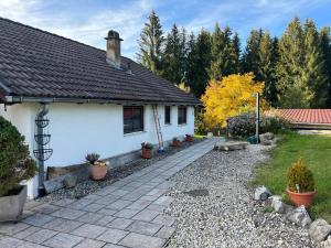 une maison blanche avec un chemin devant elle dans l'établissement Häusle in der Tannenmühle, à Seeg