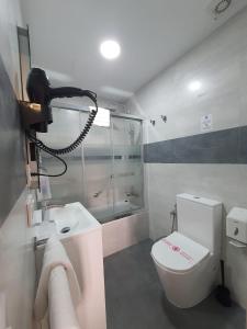 Baño pequeño con aseo y lavamanos en Apartamentos Los Angeles, en Sevilla