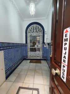 a hallway with a gate in a blue and white room at Apartamentos Los Angeles in Seville +16 photos