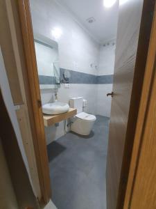 a bathroom with a white toilet and a sink at Apartamentos Los Angeles in Seville