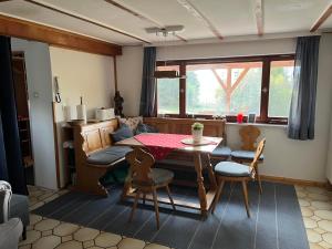 - un salon avec une table, des chaises et un canapé dans l'établissement Häusle in der Tannenmühle, à Seeg