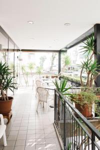 un balcone con tavoli, sedie e piante in vaso di Hotel Arlino a Rimini