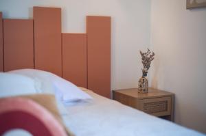 a bedroom with a bed with a vase on a table at Hôtel - Restaurant U Santu Petru in Saint-Florent