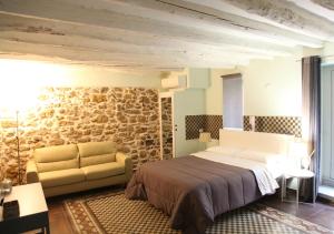 1 dormitorio con cama y pared de piedra en Chiarastella Rooms en Villafrati