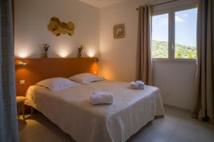 a bedroom with a bed with two towels on it at Hôtel - Restaurant U Santu Petru in Saint-Florent