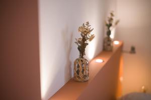 two vases sitting on a shelf with flowers in them at Hôtel - Restaurant U Santu Petru in Saint-Florent