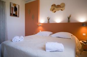 a bedroom with a white bed with towels on it at Hôtel - Restaurant U Santu Petru in Saint-Florent