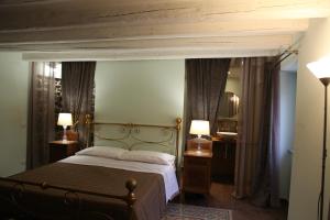 una camera con un letto, due lampade e uno specchio di Chiarastella Rooms a Villafrati
