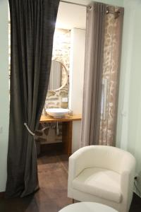 baño con silla blanca y espejo en Chiarastella Rooms en Villafrati