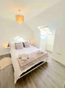Lovely 2-Bed House in St Andrews Scotland في سانت أندروز: غرفة نوم بيضاء مع سرير كبير في غرفة