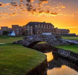 a bridge over a river in front of a building at StAndrews- Sleeps4- FamilyFriendly- NewlyRenovated in St. Andrews