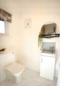 La salle de bains blanche est pourvue de toilettes et d'un lavabo. dans l'établissement Lovely 2-Bed House in St Andrews Scotland, à St Andrews
