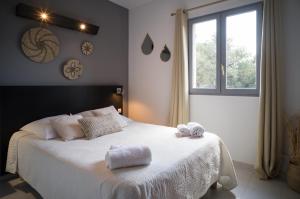 a bedroom with a white bed with towels on it at Hôtel - Restaurant U Santu Petru in Saint-Florent