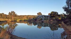a house sitting on the side of a lake at Lavandula Country House in Hepburn Springs