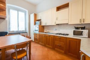 una cucina con armadi in legno, tavolo e forno a microonde di Waterfront House a Genova