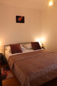 una camera da letto con un grande letto con due cuscini di Apartments KIKASO - Near Mall of Split, free parking a Spalato (Split)