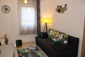 un soggiorno con divano e lampada di Apartments KIKASO - Near Mall of Split, free parking a Spalato (Split)