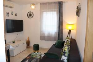 un soggiorno con divano e TV di Apartments KIKASO - Near Mall of Split, free parking a Spalato (Split)