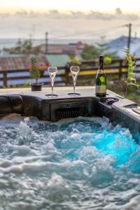 einen Whirlpool mit zwei Gläsern und einer Flasche Wein in der Unterkunft Villa, Lossy in Le Tampon