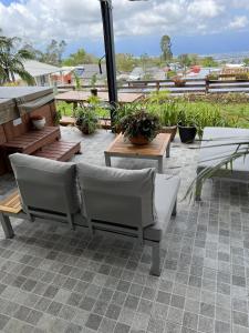 un patio con bancos y mesas en el techo en Villa, Lossy, en Le Tampon