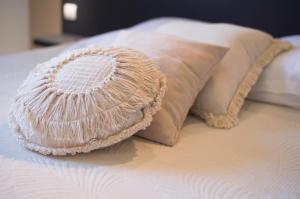 a white pillow and two pillows on a bed at Hôtel - Restaurant U Santu Petru in Saint-Florent