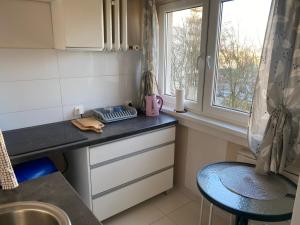 a kitchen with a counter and a sink and a window at Kawalerka 3km manufaktura in Łódź