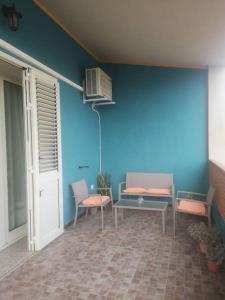 Habitación con 2 bancos y una pared azul. en L'oasi di Angela2 (I.U.N. Q5074) en San Giovanni Suèrgiu