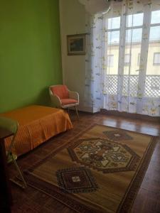 1 dormitorio con 1 cama, 1 silla y 1 alfombra en L'oasi di Angela2 (I.U.N. Q5074), en San Giovanni Suergiu